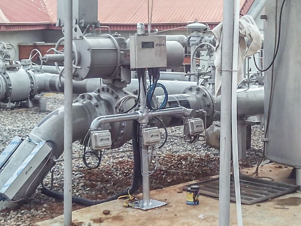 Débitmètres clamp-on installés sur des conduites industrielles dans un environnement poussiéreux.