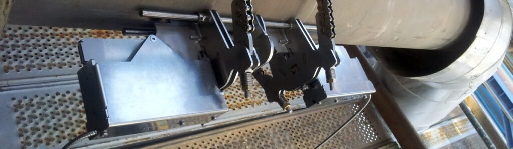 Débitmètre clamp-on non intrusif installé sur une conduite d’huile thermique pour la mesure de débit à haute température dans une installation de raffinage