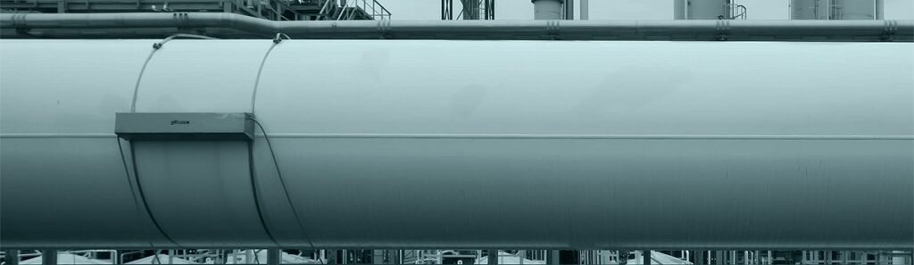 Débitmètre ultrason non intrusif de type clamp-on installé sur une grande conduite d’eau refroidissement, permettant une mesure de débit non intrusif sans perçage ni arrêt du process en environnement industriel.